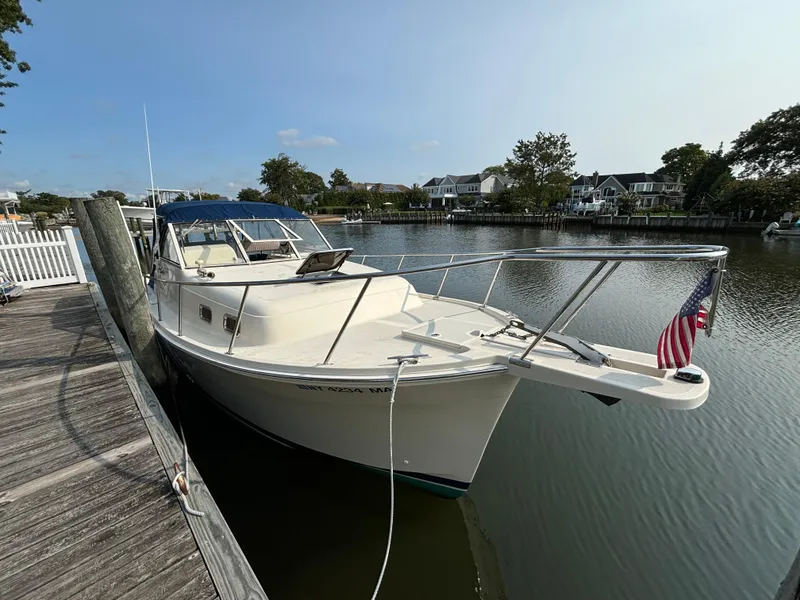 Slide: The Image of 2005 Mainship Pilot 30-II Sedan docked by a serene waterfront. - 39