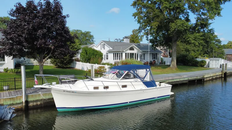 The Image of 2005 Mainship Pilot 30-II Sedan docked by a charming waterfront home. - 6
