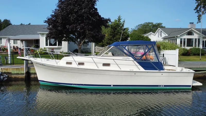 Slide: The Image of 2005 Mainship Pilot 30-II Sedan boat docked by waterfront homes. - 9