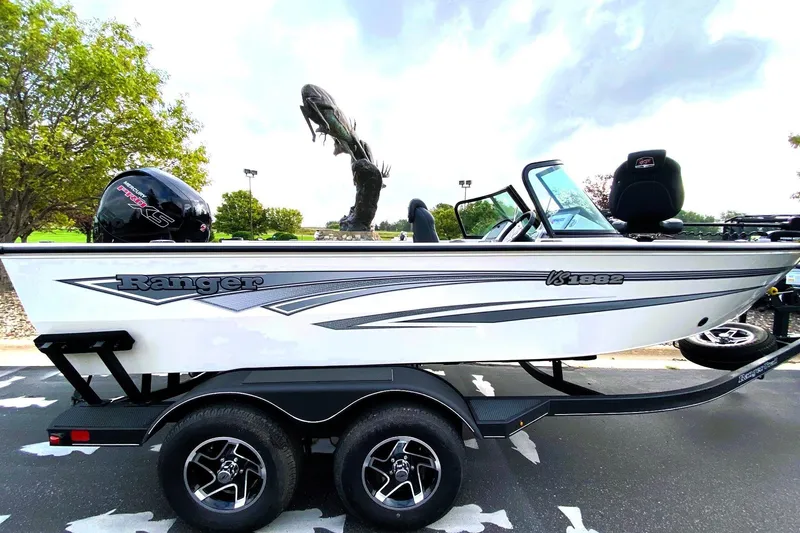 The Image of 2024 Ranger VS1882 WT boat on trailer, parked outdoors with trees in background. - 0
