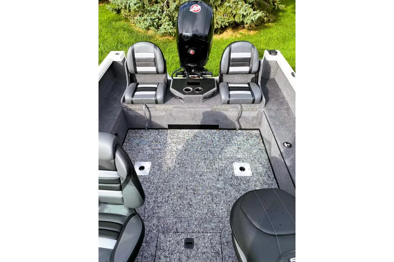 Slide: The Image of 2024 Ranger VS1882 WT boat interior with seating and motor, on grass background. - 6