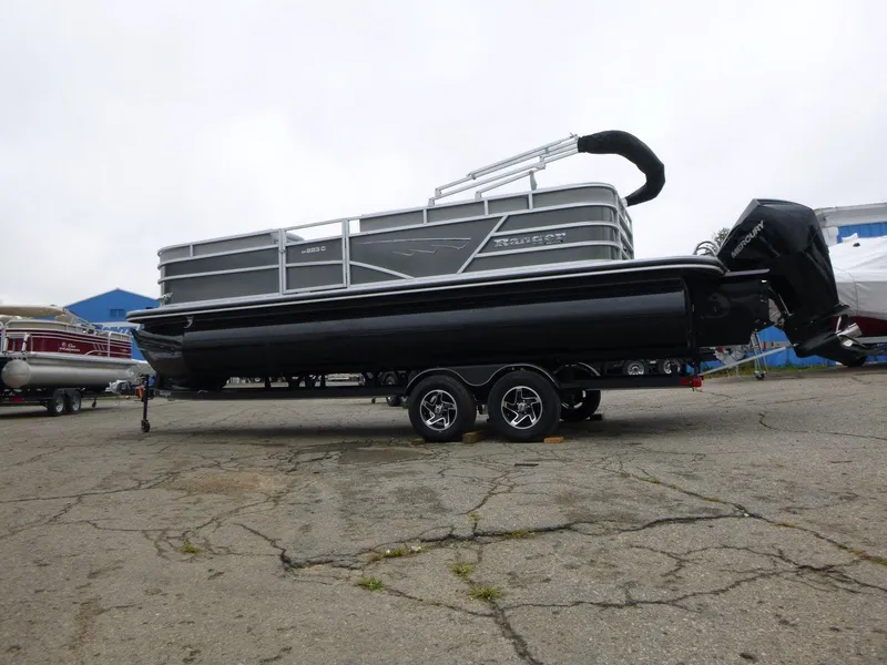 Slide: The Image of 2024 Ranger Reata 223C pontoon boat on trailer, parked outdoors. - 10