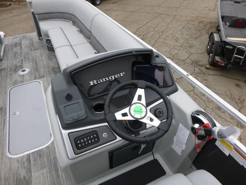 Slide: The Image of 2024 Ranger Reata 223C boat interior with steering console and seating. - 14