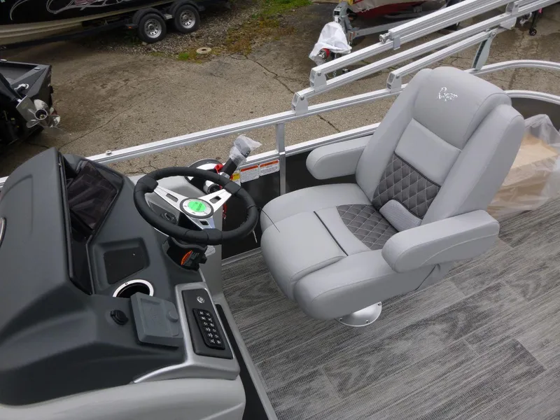 Slide: The Image of 2024 Ranger Reata 223C boat interior with steering console and plush captain's chair. - 15