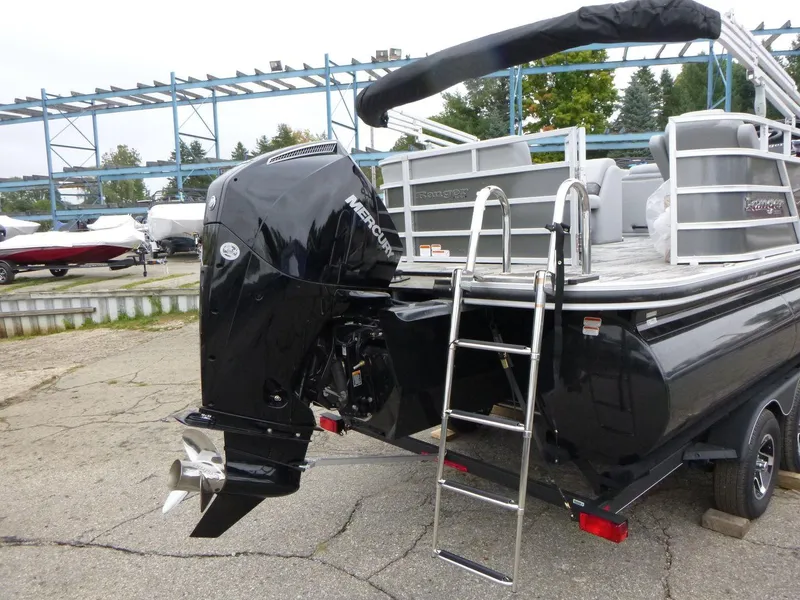 Slide: The Image of 2024 Ranger Reata 223C boat with Mercury outboard motor and ladder, parked on a trailer. - 3