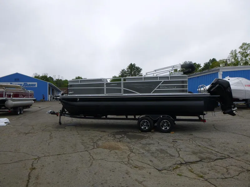 Slide: The Image of 2024 Ranger Reata 223C pontoon boat on trailer in outdoor lot. - 6