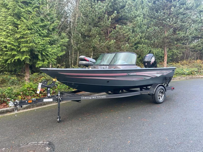 Slide: The Image of 2024 Ranger VS1682SC Reata boat on trailer, parked on a forested road. - 0