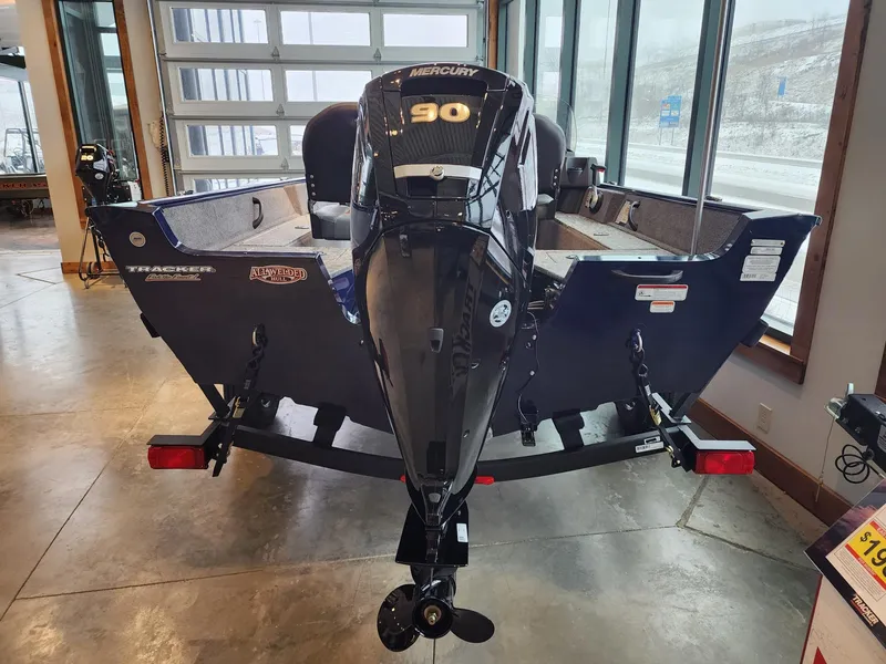 Slide: The Image of 2025 Tracker Pro Guide V-16 SC boat with Mercury 90 engine in showroom. - 4
