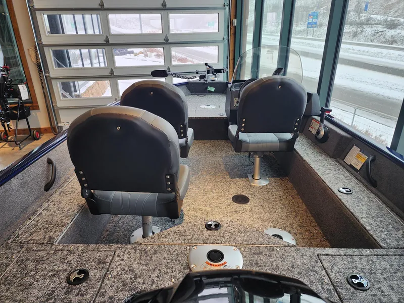 Slide: The Image of 2025 Tracker Pro Guide V-16 SC boat interior with three seats and control panel. - 6