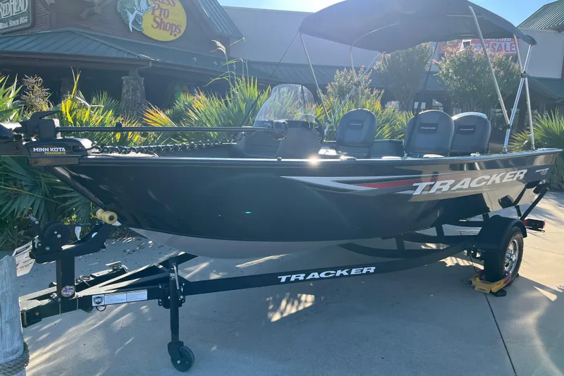 Slide: The Image of 2025 Tracker Pro Guide V-16 SC boat displayed outdoors with Minn Kota motor. - 81