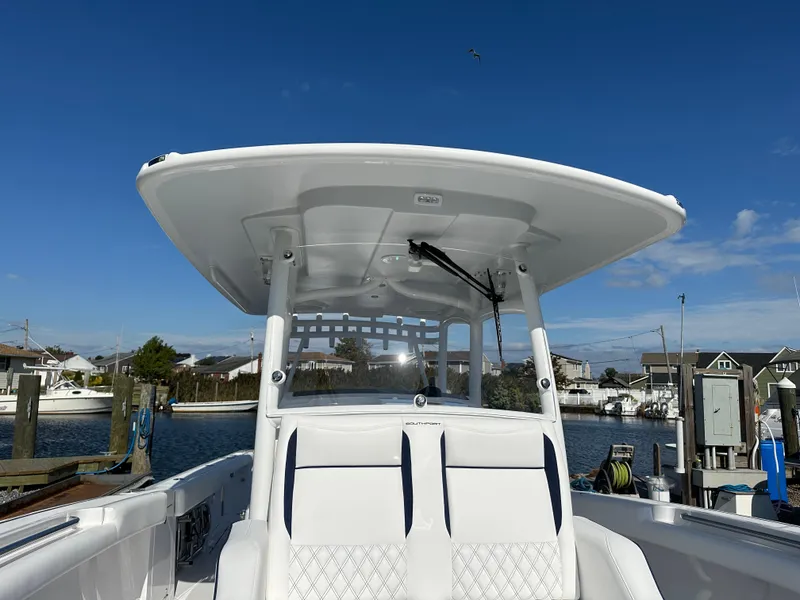 Slide: The Image of 2025 Southport 33 DC boat with T-top, docked under clear blue sky. - 12