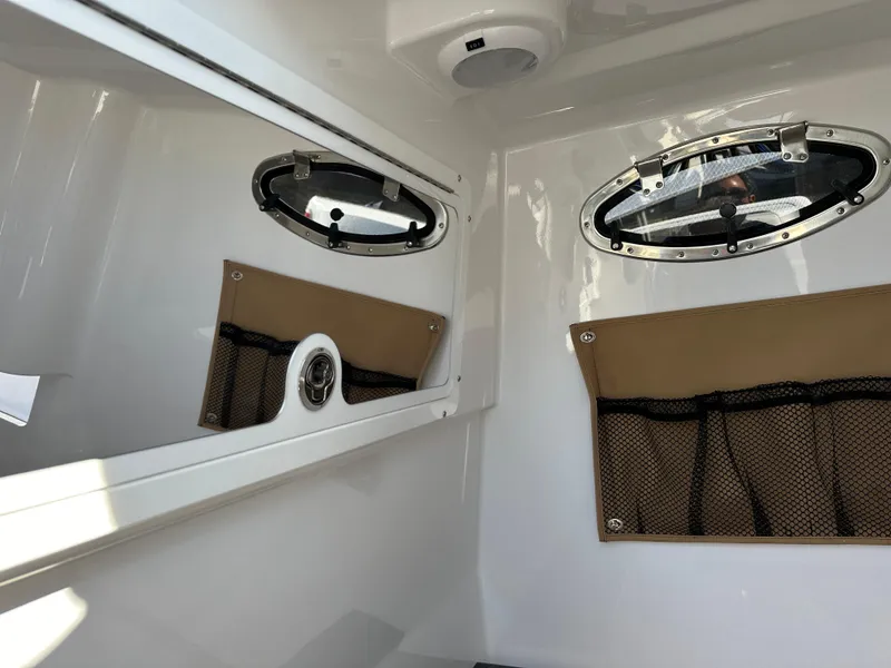 Slide: The Image of Interior cabin of 2025 Southport 33 DC boat with portholes and storage net. - 16