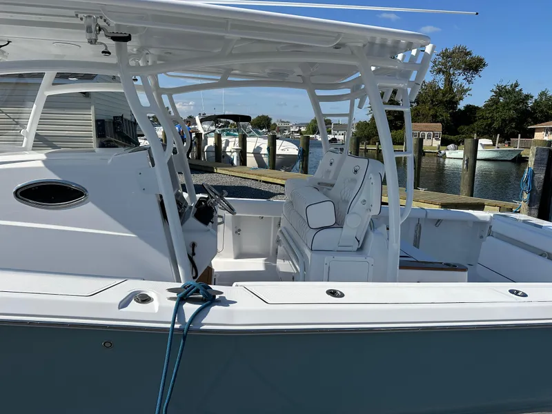 Slide: The Image of 2025 Southport 33 DC boat docked at marina, featuring spacious seating and sleek design. - 2