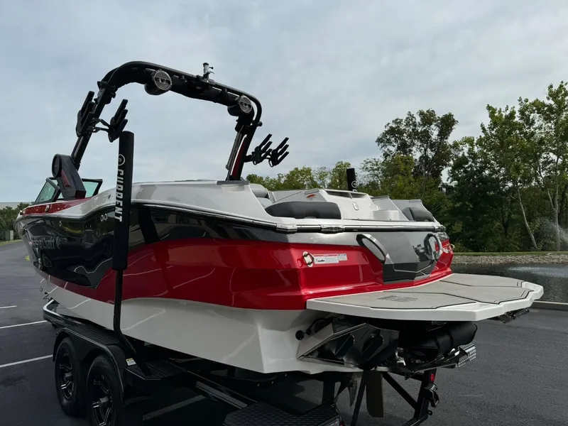 Slide: The Image of 2022 MasterCraft X24 boat with red and white design on a trailer. - 6