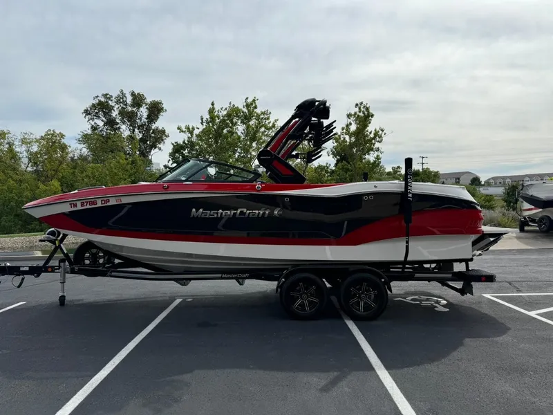Slide: The Image of 2022 MasterCraft X24 boat on trailer, parked outdoors. - 7