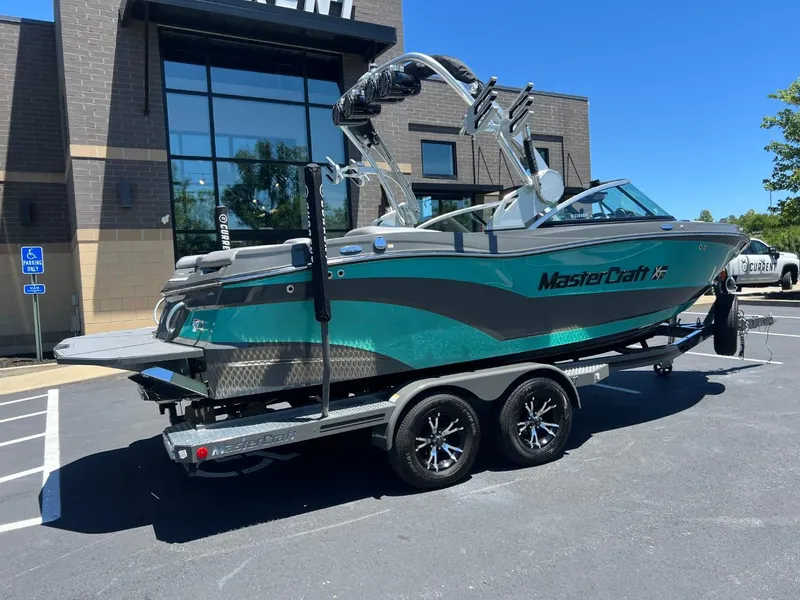 Slide: The Image of 2017 MasterCraft XT21 boat on trailer, parked outside a modern building. - 3