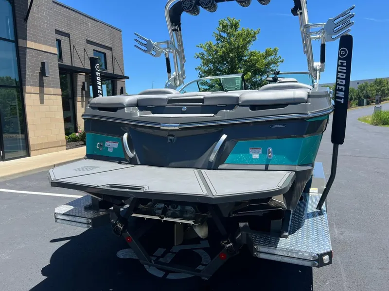Slide: The Image of 2017 MasterCraft XT21 boat, rear view, parked outdoors on a sunny day. - 4