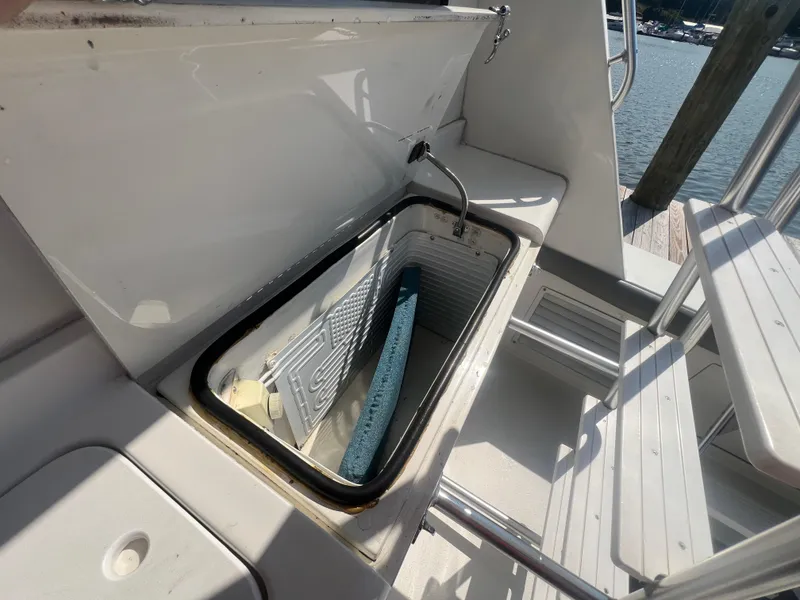 Slide: The Image of Open storage compartment on 1996 Egg Harbor Convertible boat, dockside view. - 10