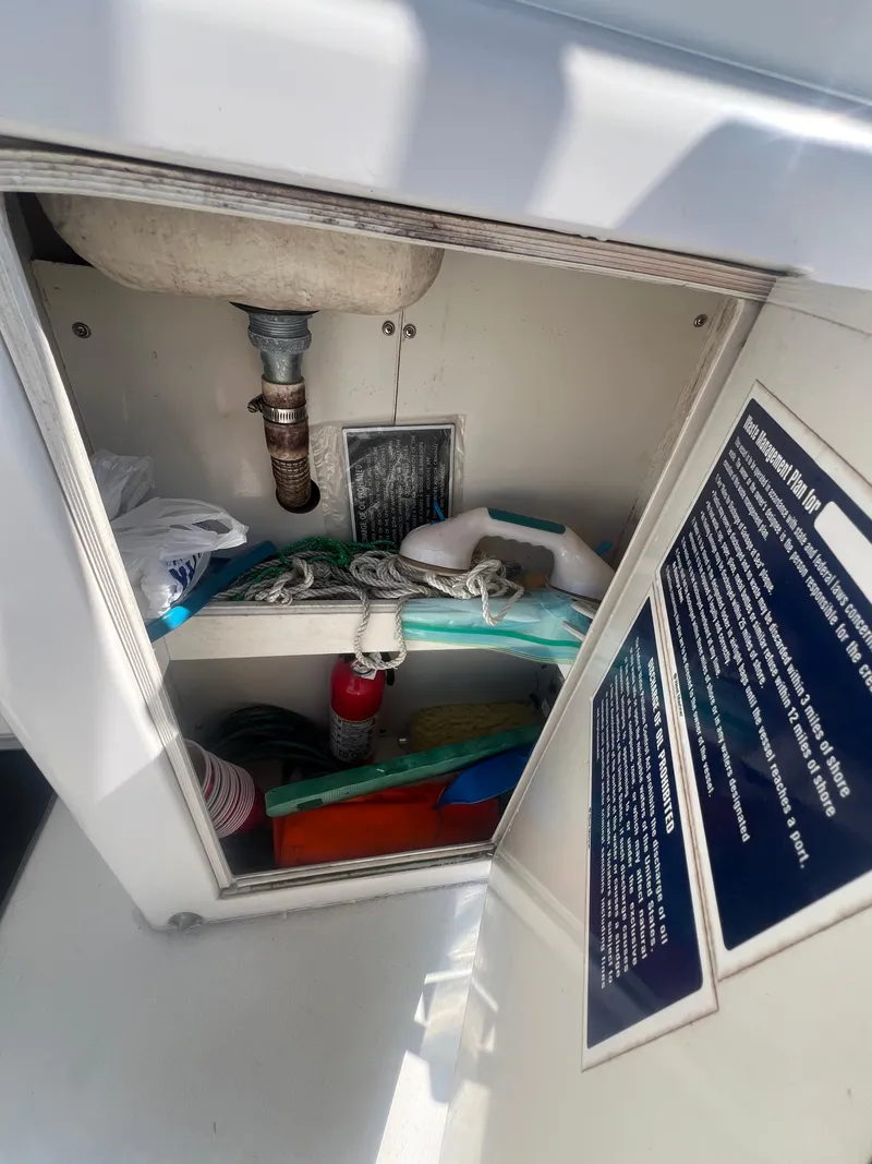 Slide: The Image of Storage cabinet on a 1996 Egg Harbor Convertible boat with safety equipment and supplies. - 11