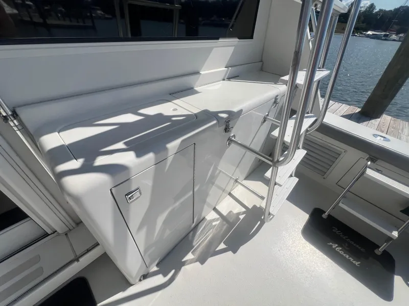 Slide: The Image of 1996 Egg Harbor Convertible yacht deck with storage and ladder, dockside view. - 12