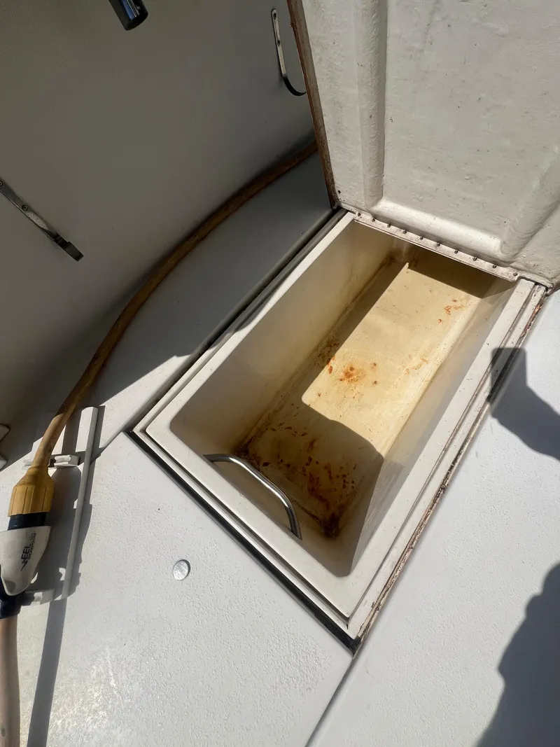 Slide: The Image of Open storage compartment on 1996 Egg Harbor Convertible boat deck. - 17