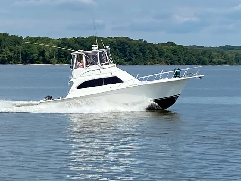 Slide: The Image of 1996 Egg Harbor Convertible boat cruising on a calm lake. - 2