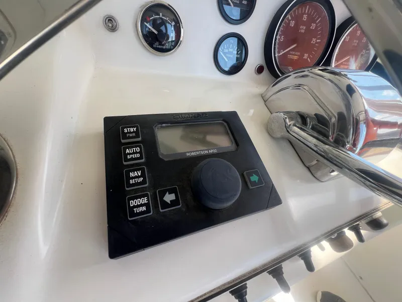 Slide: The Image of 1996 Egg Harbor Convertible boat dashboard with Simrad autopilot controls and gauges. - 25