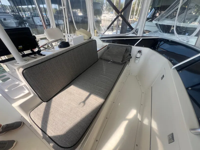 Slide: The Image of 1996 Egg Harbor Convertible boat interior with cushioned seating and helm station. - 33