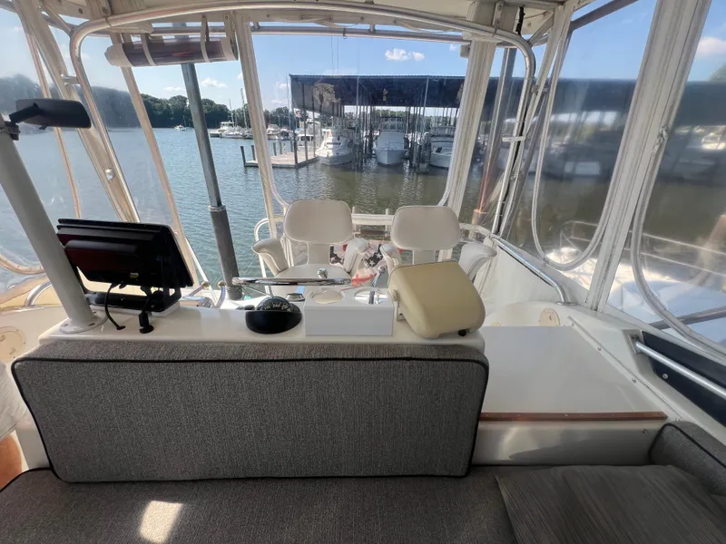Slide: The Image of Interior view of 1996 Egg Harbor Convertible boat at marina, featuring helm and seating area. - 34