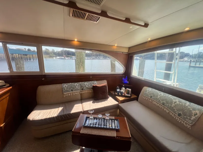 Slide: The Image of Interior of a 1996 Egg Harbor Convertible yacht with cozy seating and waterfront view. - 42