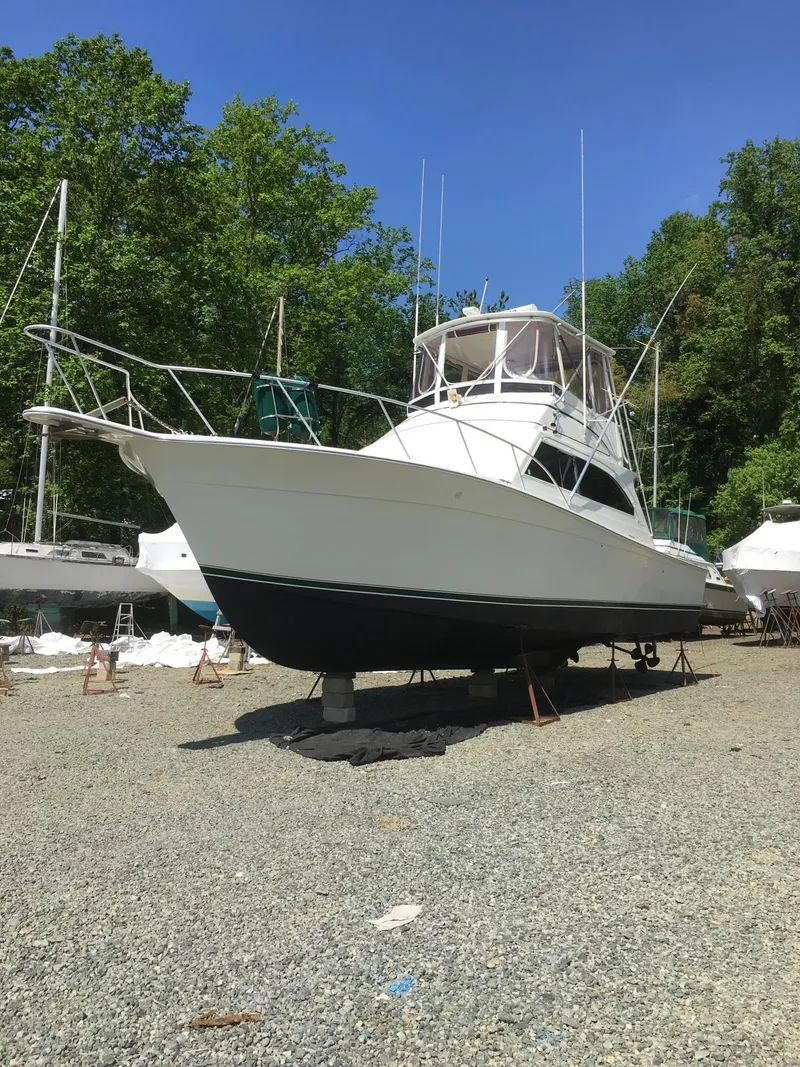 Slide: The Image of 1996 Egg Harbor Convertible boat on dry dock, surrounded by trees. - 6