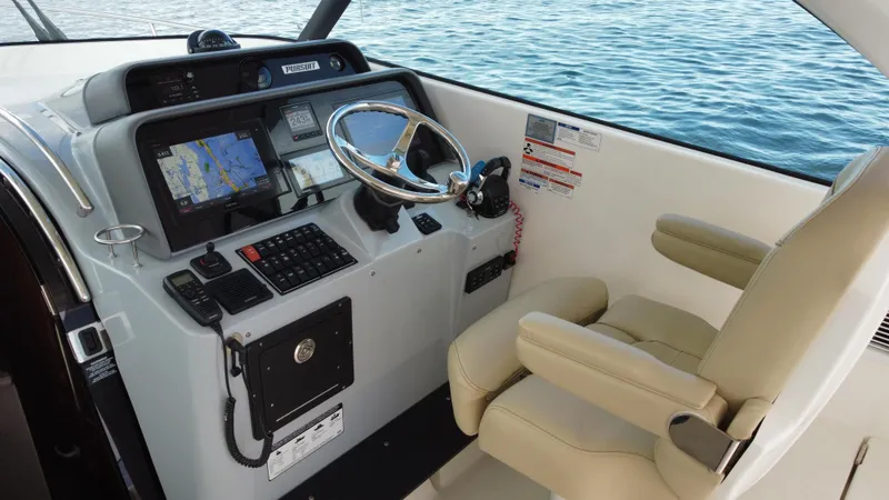 Slide: The Image of 2020 Pursuit OS 385 Offshore helm with navigation system and beige captain's chair. - 15