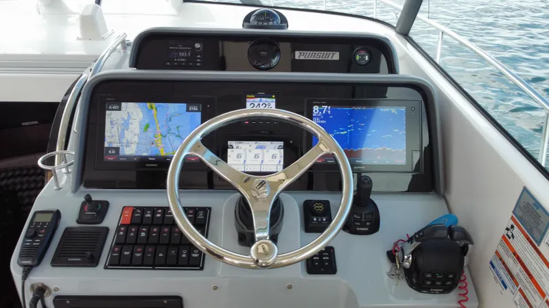 Slide: The Image of 2020 Pursuit OS 385 Offshore helm with navigation screens and controls. - 16