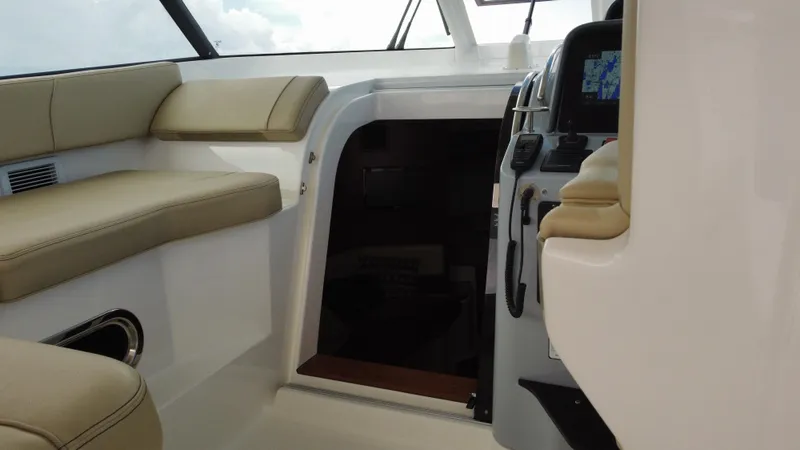 Slide: The Image of 2020 Pursuit OS 385 Offshore interior with beige seating and navigation controls. - 21
