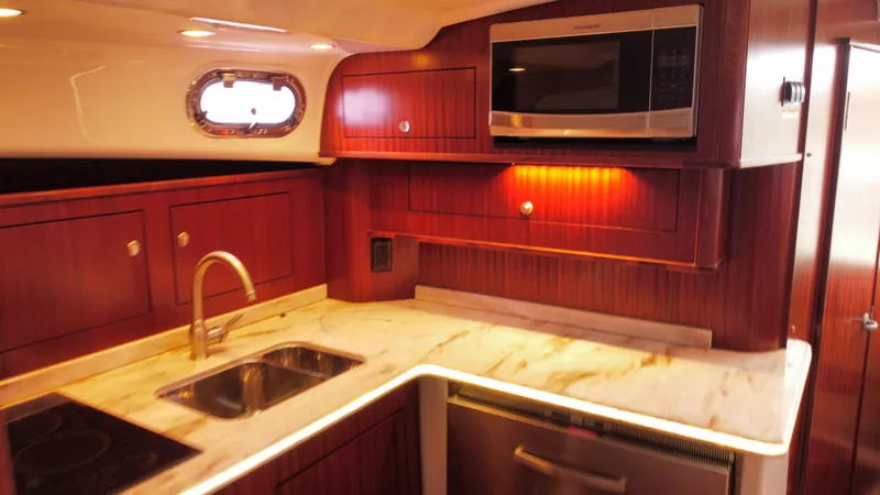 Slide: The Image of Luxurious 2020 Pursuit OS 385 Offshore yacht kitchen with wood cabinetry and modern appliances. - 22