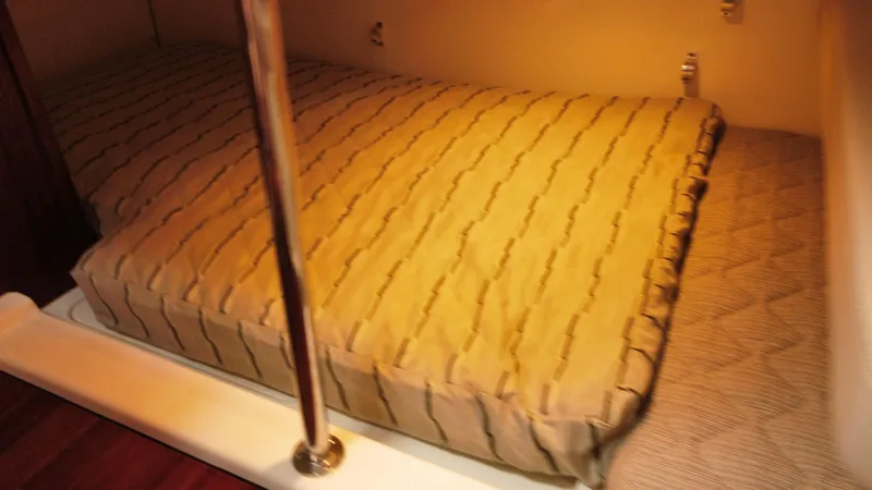 Slide: The Image of 2020 Pursuit OS 385 Offshore cabin with cozy bed and warm lighting. - 25