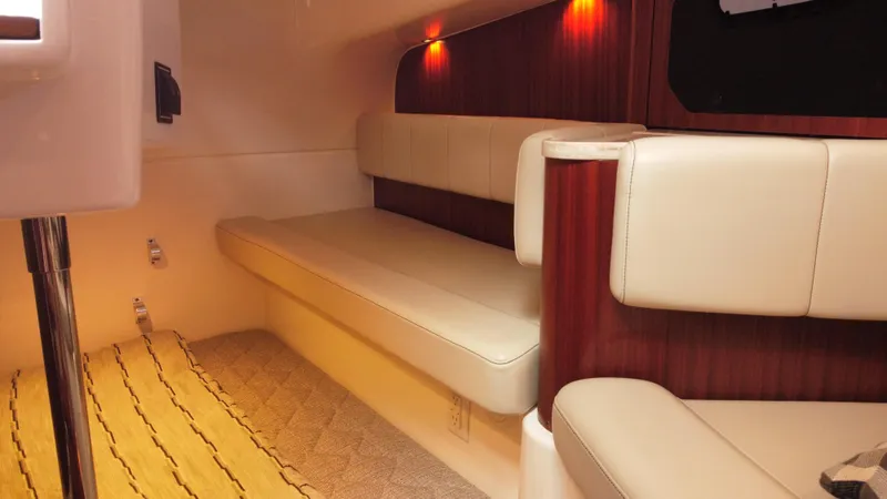 Slide: The Image of 2020 Pursuit OS 385 Offshore cabin interior with beige seating and warm lighting. - 26