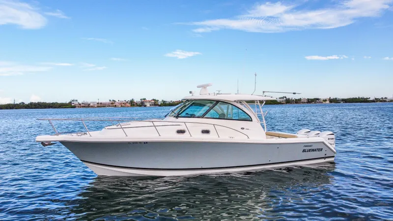 Slide: The Image of 2020 Pursuit OS 385 Offshore boat on calm water under blue sky. - 3