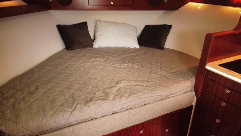 Slide: The Image of Cozy cabin bed in 2020 Pursuit OS 385 Offshore boat with pillows and wood accents. - 32