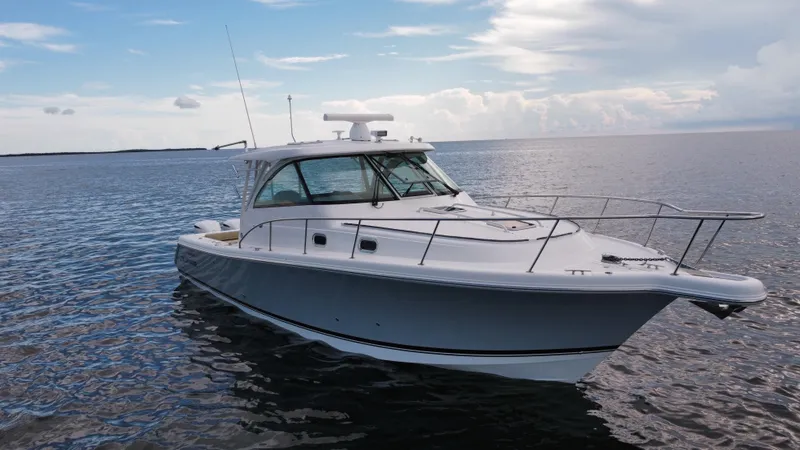 Slide: The Image of 2020 Pursuit OS 385 Offshore boat on calm water under a cloudy sky. - 33