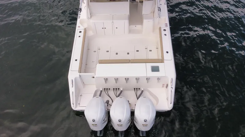 Slide: The Image of 2020 Pursuit OS 385 Offshore boat with triple outboard engines on water. - 37