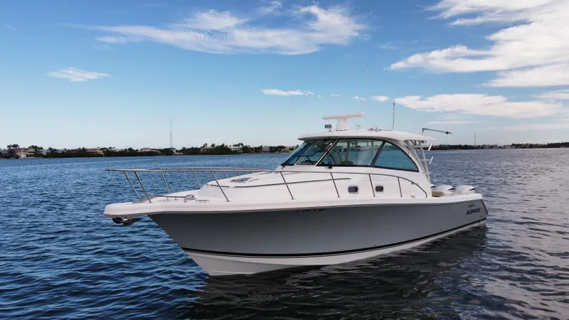 Slide: The Image of 2020 Pursuit OS 385 Offshore boat on calm water under blue sky. - 38