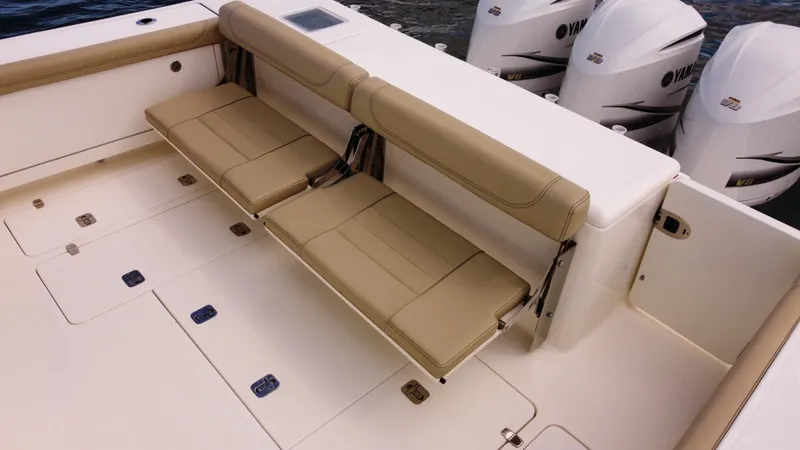 Slide: The Image of 2020 Pursuit OS 385 Offshore boat with beige seating and triple outboard engines. - 6