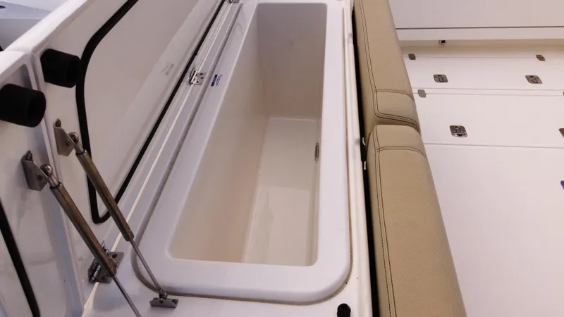 Slide: The Image of 2020 Pursuit OS 385 Offshore boat storage compartment with cushioned seating. - 9