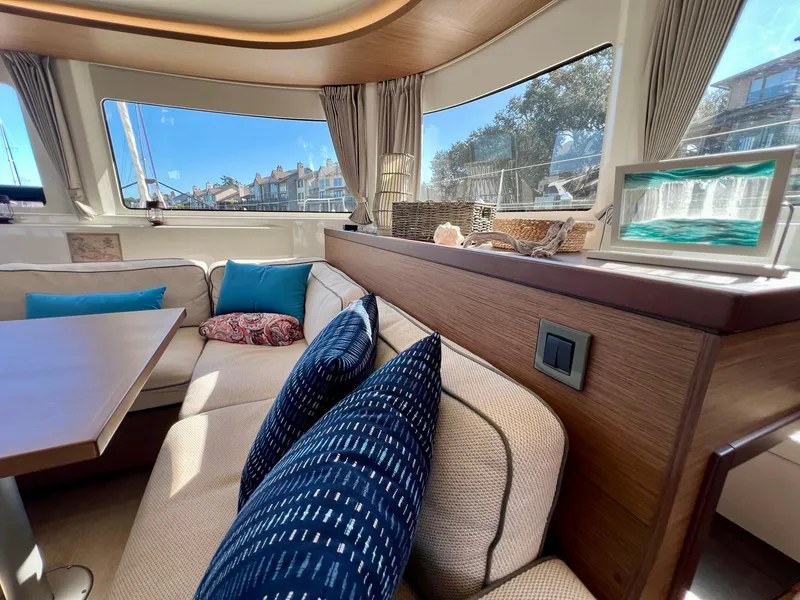 Slide: The Image of Luxurious interior of 2022 Lagoon 46 catamaran with plush seating and scenic windows. - 16
