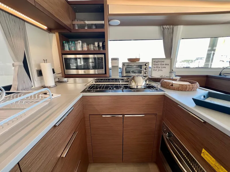 Slide: The Image of Modern kitchen in 2022 Lagoon 46 yacht with wood cabinetry and stainless steel appliances. - 19