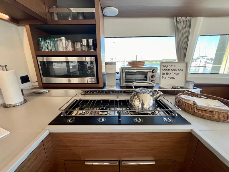 Slide: The Image of Modern kitchen in 2022 Lagoon 46 yacht with stove, microwave, and ocean view. - 20