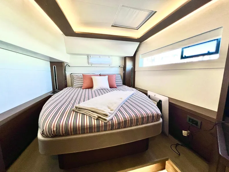 Slide: The Image of Luxurious bedroom interior of 2022 Lagoon 46 yacht with striped bedding and modern lighting. - 30