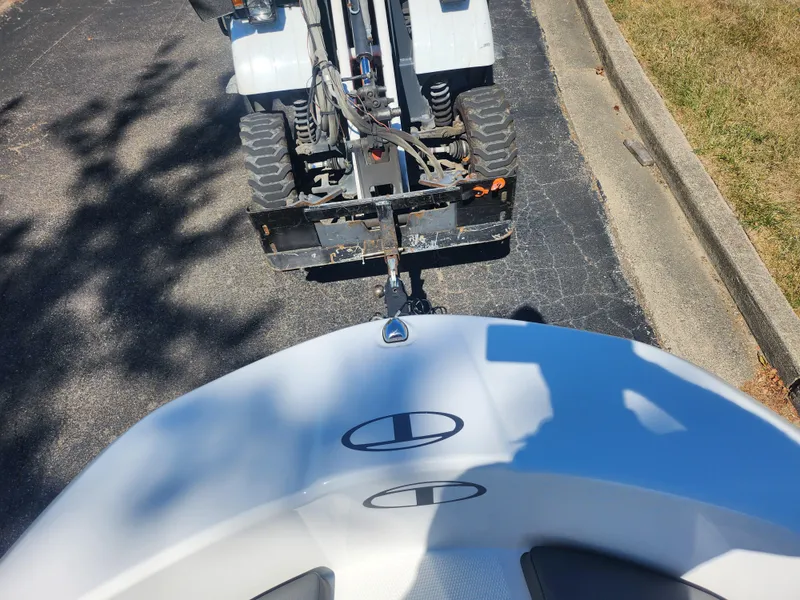 Slide: The Image of 2021 Tahoe T16 boat being towed by a small vehicle on a paved road. - 15