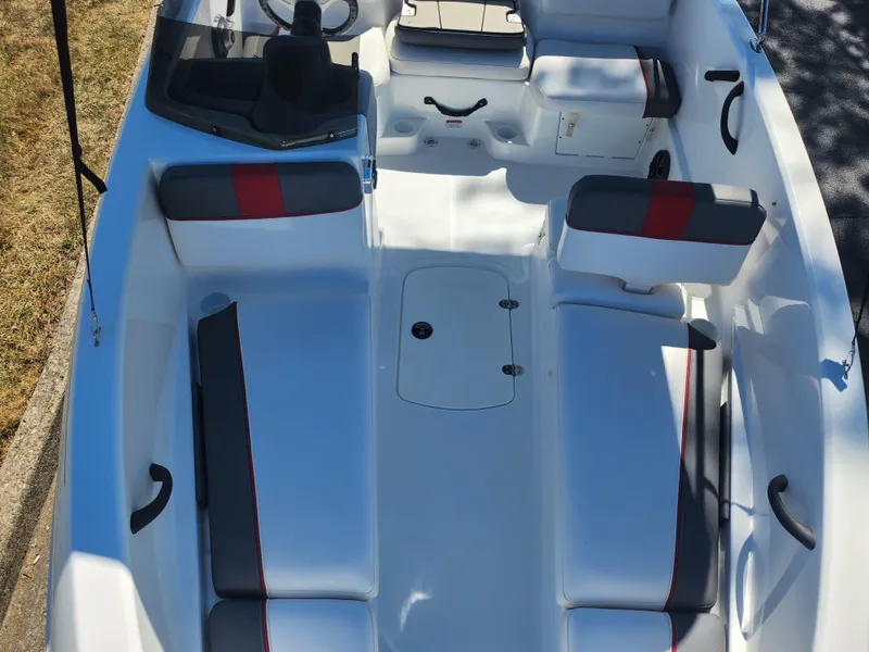 Slide: The Image of 2021 Tahoe T16 boat interior with white and gray seating, red accents, and steering console. - 16